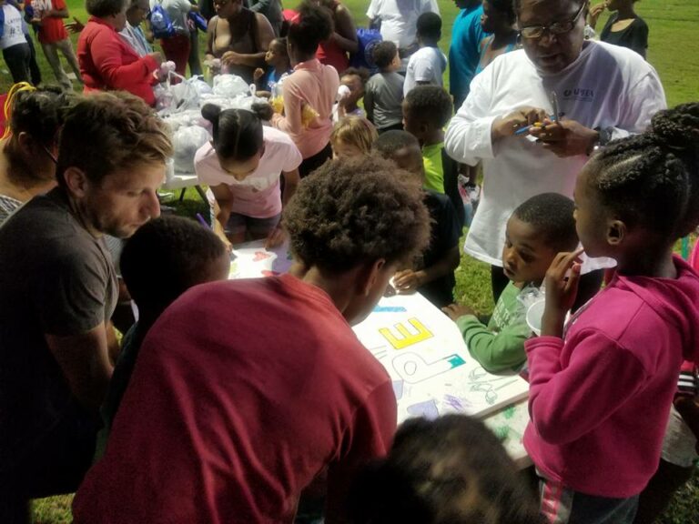 Children and volunteers gathered around table for Bunny Friend Neighborhood Association event
